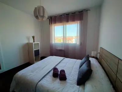 a bedroom with a bed with two slippers on it at Boa Vista Cerca del centro 2 hab y parking in Monforte de Lemos
