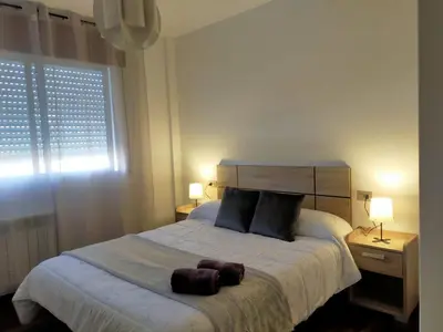 a bedroom with a bed with two pillows and a window at Boa Vista Cerca del centro 2 hab y parking in Monforte de Lemos