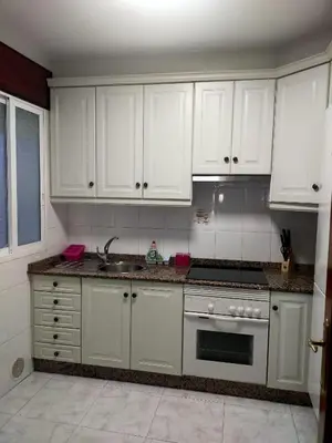 a kitchen with white cabinets and a sink at Boa Vista Cerca del centro 2 hab y parking in Monforte de Lemos