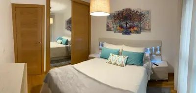 a bedroom with a white bed with blue pillows at VIANA in Monforte de Lemos