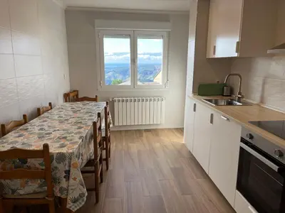 a kitchen with a table and chairs and a kitchen with a window at Casa Manuela in Castro Caldelas