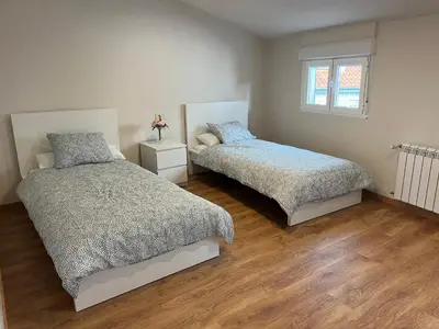 a bedroom with two beds and a window at Casa Manuela in Castro Caldelas