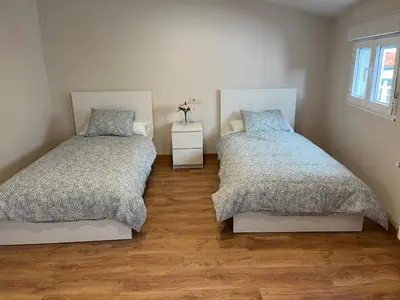 a bedroom with two beds and a wooden floor at Casa Manuela in Castro Caldelas