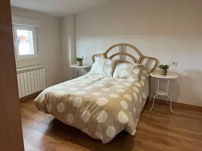 a bedroom with a bed with two tables and a window at Casa Manuela in Castro Caldelas