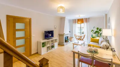a living room with a table and a tv at Casa Naseiro in Melide