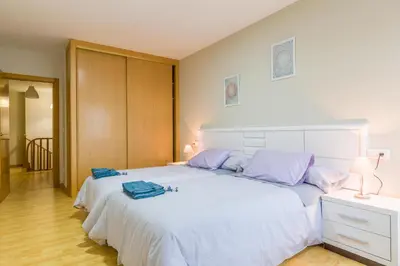 a bedroom with a large white bed with purple pillows at Casa Naseiro in Melide