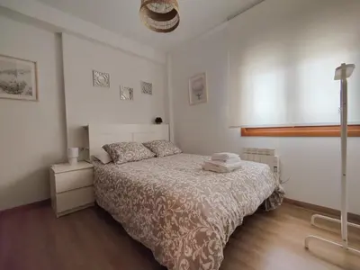 a bedroom with a bed in a white room at Céntrico, 100 metros de la playa, reformado,163 m2 in Foz