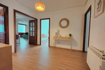 a living room with a wooden floor and a table at Céntrico, 100 metros de la playa, reformado,163 m2 in Foz