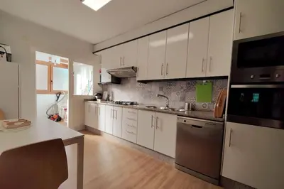 a kitchen with white cabinets and stainless steel appliances at Céntrico, 100 metros de la playa, reformado,163 m2 in Foz