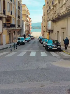 a street with cars parked on the side of a road at Céntrico, 100 metros de la playa, reformado,163 m2 in Foz
