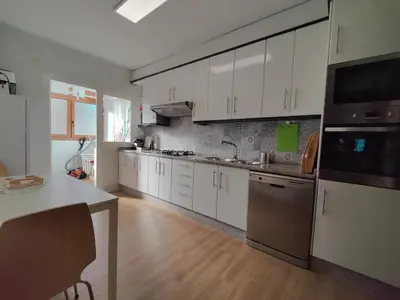 a kitchen with white cabinets and stainless steel appliances at Céntrico, 100 metros de la playa, reformado,163 m2 in Foz