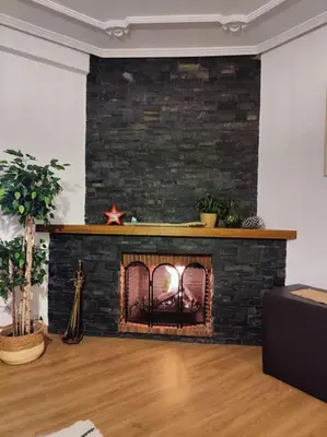 a living room with a fireplace with a brick wall at Céntrico, 100 metros de la playa, reformado,163 m2 in Foz