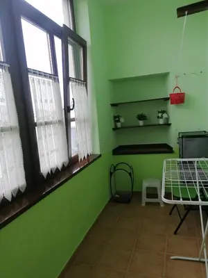 a green room with two windows and a bed at NIDO in Ribadeo