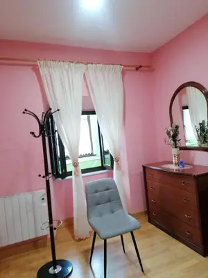 a room with a chair and a dresser and a mirror at NIDO in Ribadeo