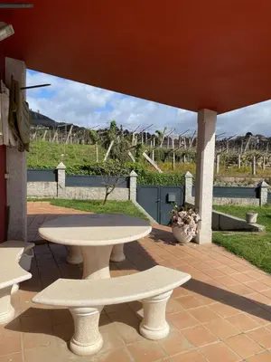 a picnic table and two benches on a patio at Chalet casa con piscina en ARBO Vigo in Arbo
