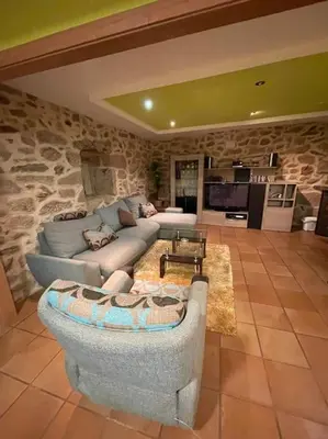 a living room with a couch and a stone wall at Chalet casa con piscina en ARBO Vigo in Arbo