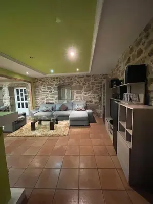 a living room with a couch and a stone wall at Chalet casa con piscina en ARBO Vigo in Arbo