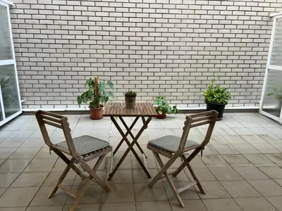 a table and two chairs on a patio with plants at BierzINN Alojamientos - Brujas in Ponferrada