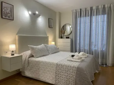 a bedroom with a white bed and a mirror at BierzINN Alojamientos - Brujas in Ponferrada