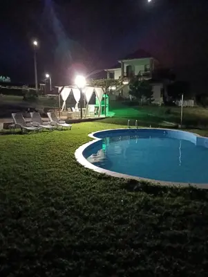a swimming pool at night with tents in the background at O FOGAR DAS FINAS in Melias
