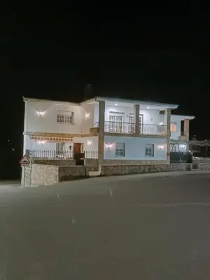 a white house with a balcony at night at O FOGAR DAS FINAS in Melias
