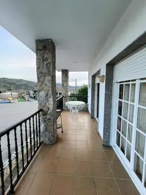 a balcony of a house with a table at O FOGAR DAS FINAS in Melias