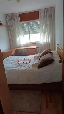 a white bed with two towels and a flower on it at Tu piso en el Camino de Santiago in Sarria