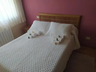 two stuffed animals on a bed with white sheets at Tu piso en el Camino de Santiago in Sarria