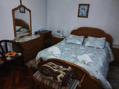 a bedroom with a bed with a dresser and a mirror at Casa Jesús in Sarria
