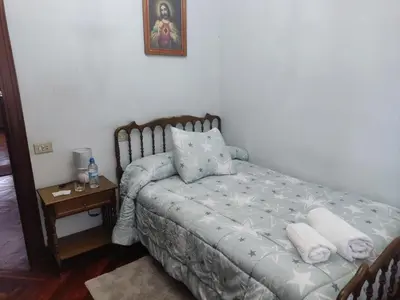 a bedroom with a bed and a table with a night stand at Casa Jesús in Sarria