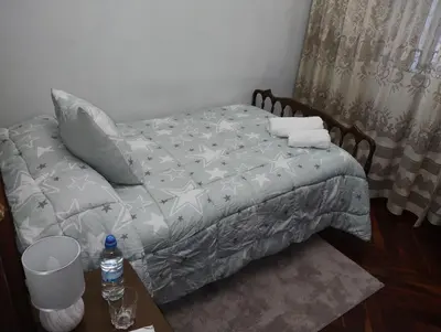 a bedroom with a bed and a table with a bottle of water at Casa Jesús in Sarria
