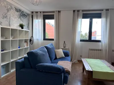 a living room with a blue couch and a table at Apartamento La Emisora in Ponferrada