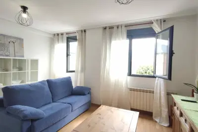 a blue couch in a living room with a window at Apartamento La Emisora in Ponferrada