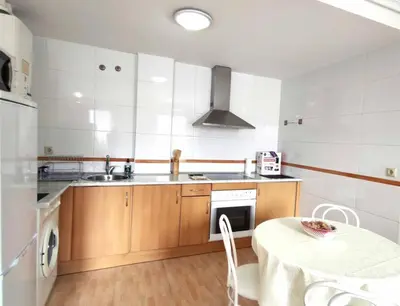a kitchen with a table and a sink and a stove at Apartamento La Emisora in Ponferrada