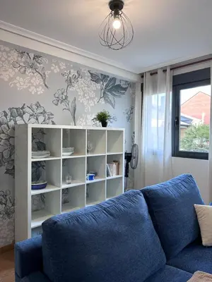 a living room with a blue couch and a book shelf at Apartamento La Emisora in Ponferrada