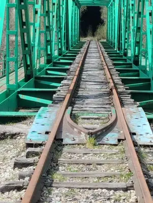 an old train track with a green bridge at VUT El Refugio in Villablino