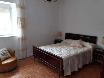 a bedroom with a large bed and a chair at VUT El Refugio in Villablino