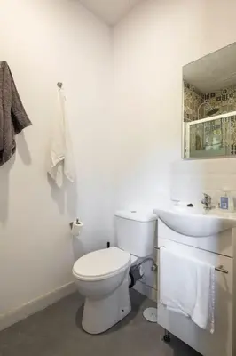 a white bathroom with a toilet and a sink at Casona con Jacuzzi in Betanzos