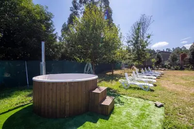 a hot tub in a yard with a group of chairs at Casona con Jacuzzi in Betanzos