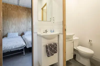 a bathroom with a sink and a toilet and a bed at Casona con Jacuzzi in Betanzos