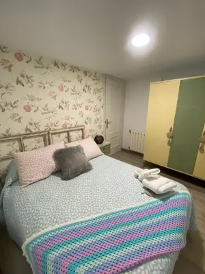 a bedroom with a bed with a colorful blanket at Casa Los Cuncos in Barrio de Lomba