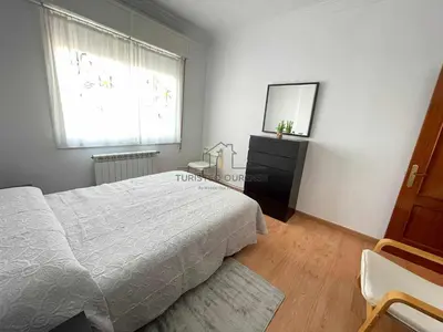 a bedroom with a bed and a dresser and a window at O cuarto de abastos in Ourense
