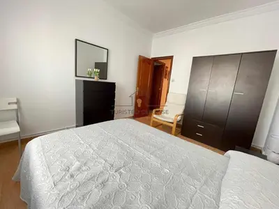a bedroom with a bed and a dresser and a mirror at O cuarto de abastos in Ourense
