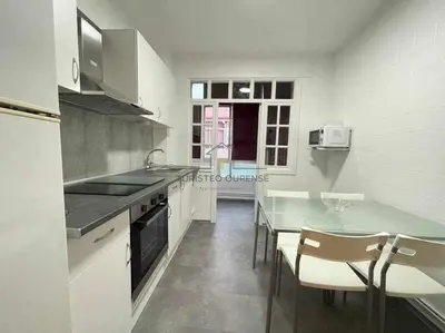 a kitchen with a counter and a table and chairs at O cuarto de abastos in Ourense