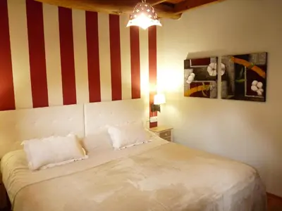 a bedroom with a bed with red and white stripes at Apartamentos Rurales CASONA DE LOLO in Caunedo