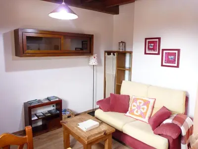 a living room with a couch and a table at Apartamentos Rurales CASONA DE LOLO in Caunedo
