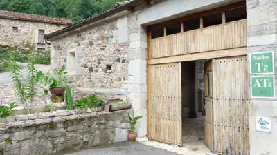 an entrance to a stone building with a wooden door at Apartamentos Rurales CASONA DE LOLO in Caunedo