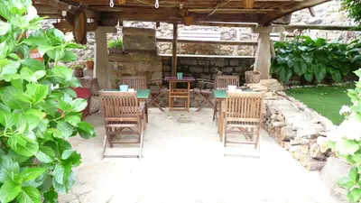 a patio with chairs and tables and a stone fireplace at Apartamentos Rurales CASONA DE LOLO in Caunedo