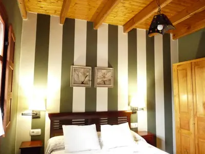 a bedroom with green and white striped walls and a bed at Apartamentos Rurales CASONA DE LOLO in Caunedo