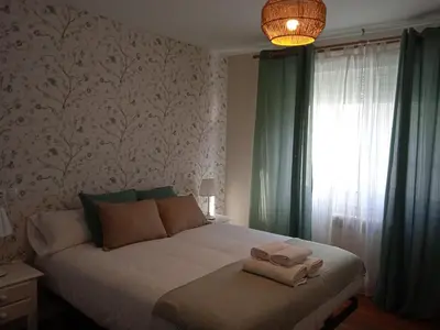 a bedroom with a bed with two towels on it at O Refuxio de Sigüeiro # a 10 min de Santiago in Sigüeiro